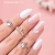 Paznokcie przedłużone żelem budującym z pamięcią cieczy. Manicure z wykorzystaniem żelu w kolorze jasny różowy i jasnego szarego lakieru hybrydowego.