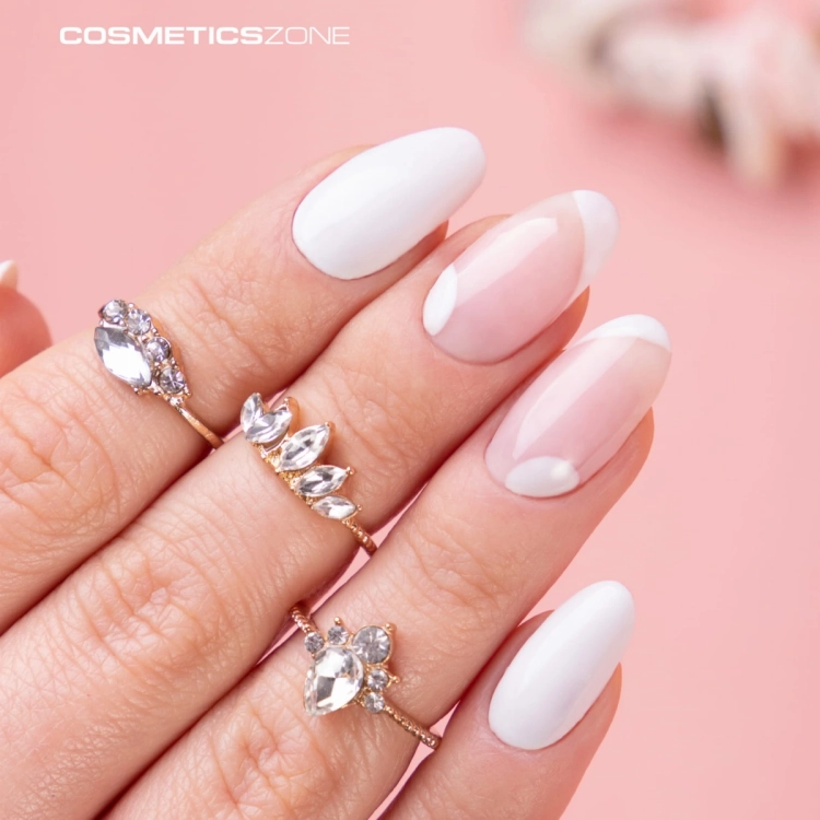 Paznokcie przedłużone żelem budującym z pamięcią cieczy. Manicure z wykorzystaniem żelu w kolorze jasny różowy i jasnego szarego lakieru hybrydowego.