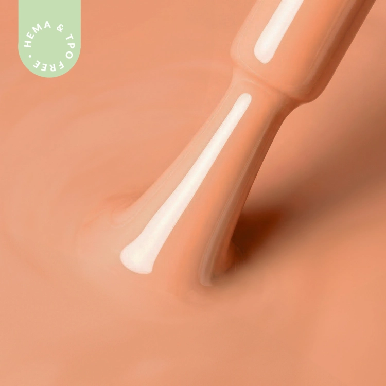 Zbliżenie na pędzelek zanurzony w lakierze hybrydowym A020 Apricot Glow – ciepły, morelowy kolor o kremowym wykończeniu.