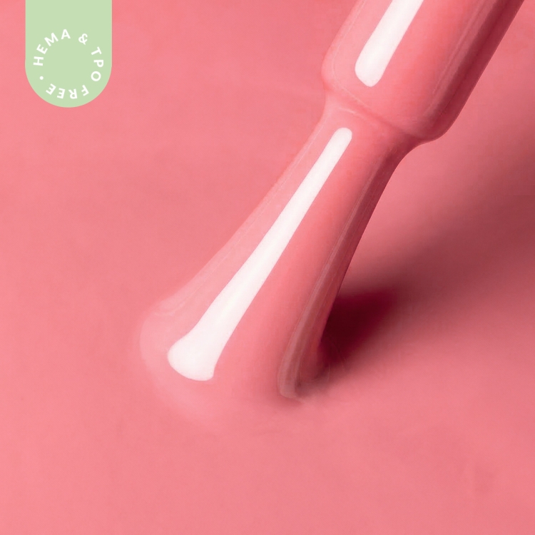 Zbliżenie na pędzelek zanurzony w lakierze hybrydowym A021 Peony Blush – subtelny, różowy kolor o kremowym wykończeniu.