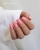 Dłonie z manicure hybrydowym w kolorze A021 – delikatny, cukierkowy róż na paznokciach o kwadratowym kształcie.