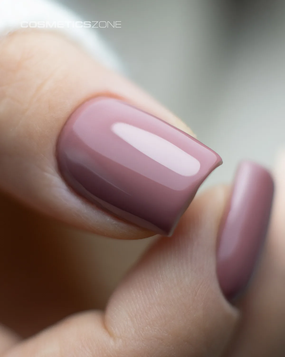kobieca dłoń. Manicure hybrydowy, paznokcie pomalowane brązowym lakierem hybrydowym